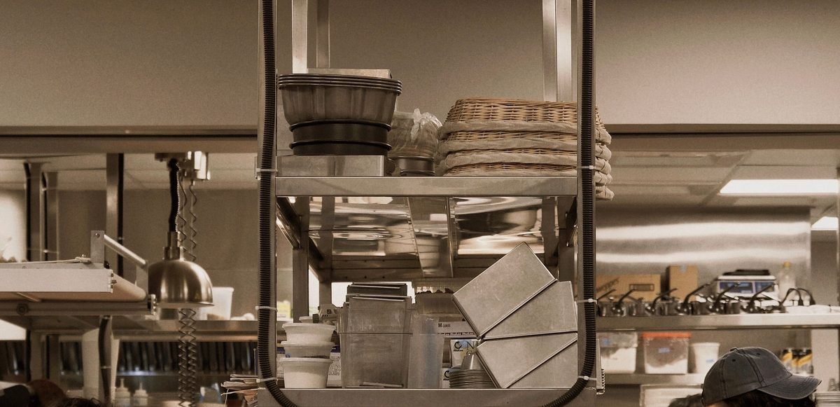 Heat lamps and stacked service ware above a restaurant expo pass